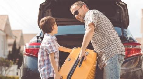 Man en jongen pakken koffer voor vakantie